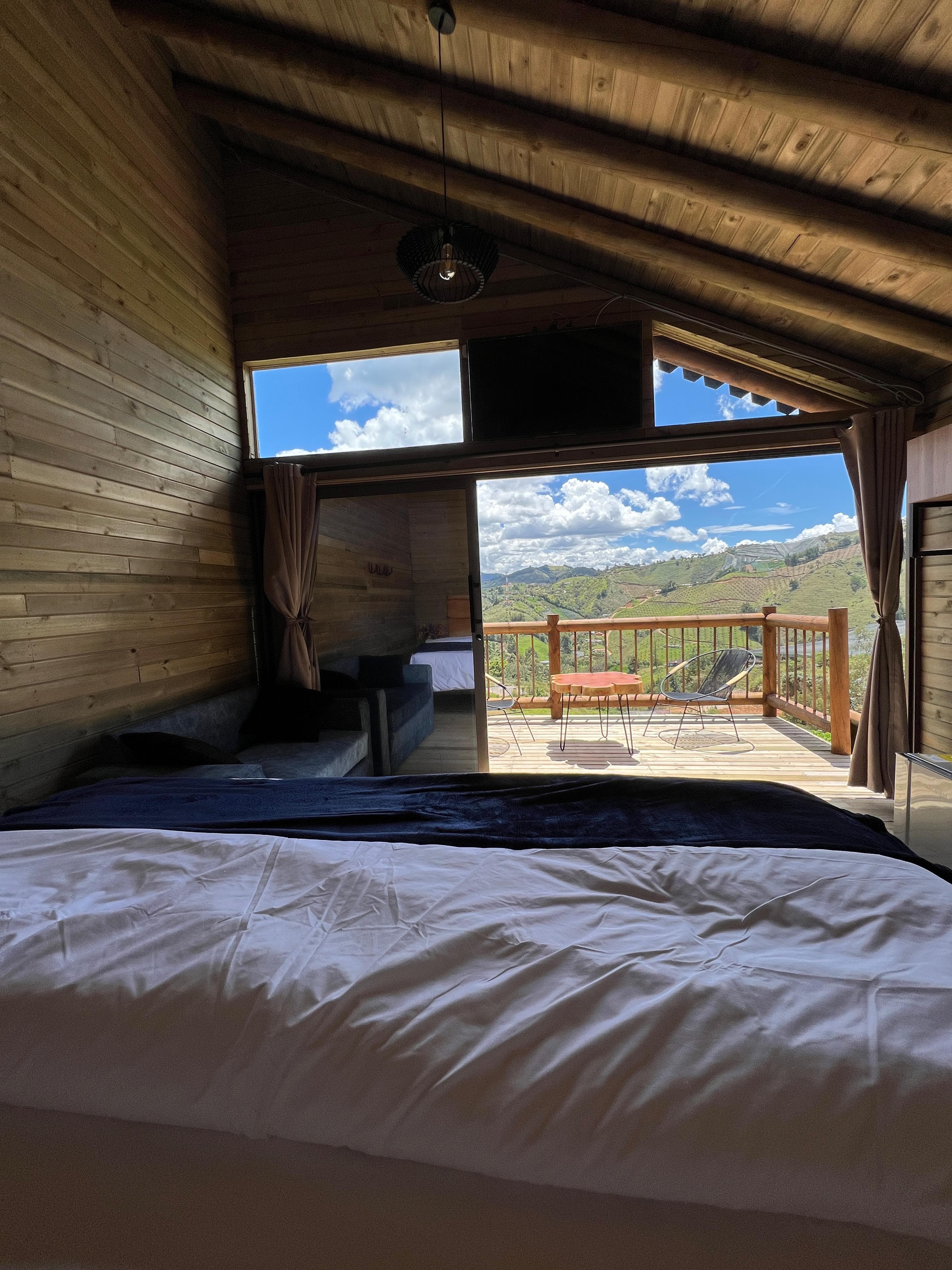 Habitación con cama doble y balcón al valle