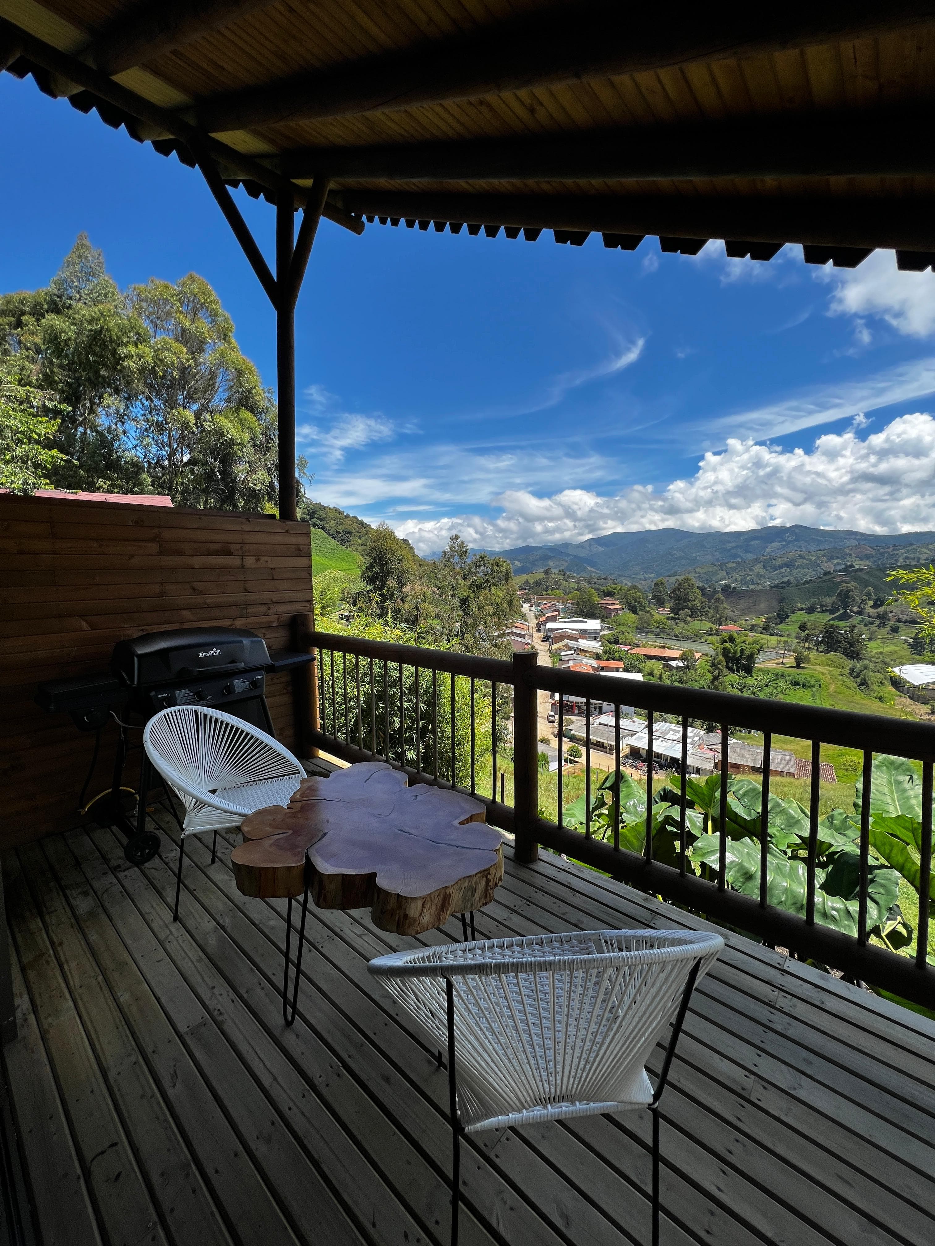 Terraza con sillas blancas y vista al pueblo